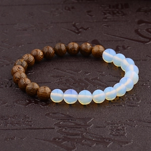 Close-up of wood bead bracelet with opal stones on a decorative vintage scroll background