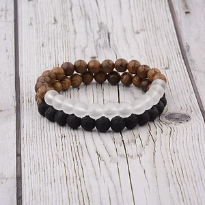 Close-up of beaded bracelets set with natural brown wood and black lava stone beads