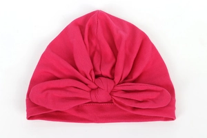 Close-up of soft cotton baby turban hat in deep pink with a large decorative bow