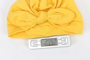 Detailed view of lightweight yellow baby turban hat with bow knot weighing 26.2g