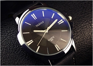Detail view of quartz watch with black textured dial and silver luminous hands