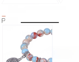 Detail of natural snakeskin stone beads with vintage silver tree of life charm