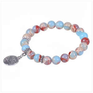 Detail of beaded tree of life bracelet featuring blue natural stones and silver charm
