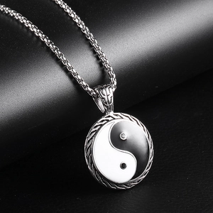 Macro view of Tai Chi Yin Yang pendant with zircons on a vintage box chain necklace