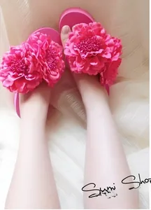 Detail of fuchsia platform flip-flops featuring oversized 3D fabric peony flower decor