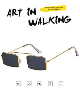 Detail view of rectangular sunglasses with gold metal frame and dark grey HD lenses