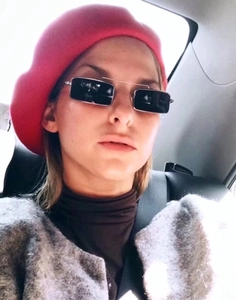 Close-up of lifestyle wear featuring retro square black sunglasses with a red beret