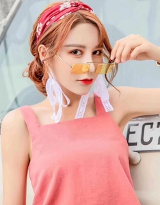 Outdoor close-up of yellow rectangular sunglasses and floral headband on model