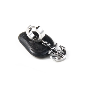 Polished silver stainless steel anchor hoop earring for men on black pebble stone