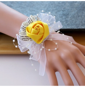 Détail du bracelet fleur en satin jaune avec résille blanche, perles et rubans imprimés
