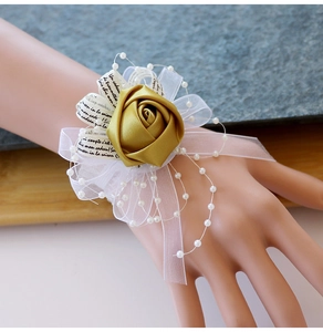 Détail de corsage de poignet de mariage avec rose en satin doré, tulle blanc et perles