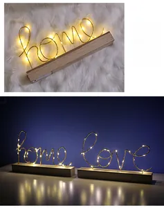 Makro-Detail von LED-Buchstaben Home und Love mit Holzsockel und warmem Licht