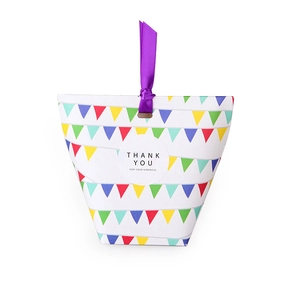Close-up of white gift box with colorful bunting print and a purple ribbon handle