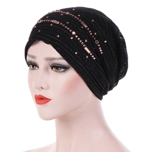 Close-up of black lace turban hat with rose gold rhinestones and sparkling beadwork