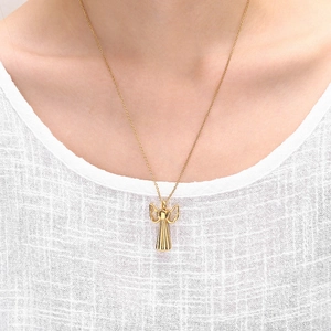 Gold angel wing pendant necklace in stainless steel worn by a model on white clothes