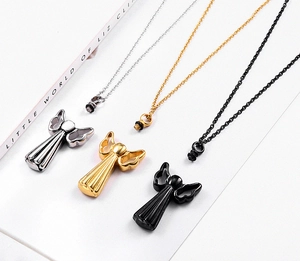 Detailed view of angel wing cremation pendants in silver, gold, and black steel
