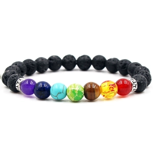 Lava rock and seven chakra stone beaded yoga bracelet with metal spacers on white background