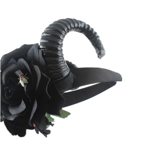Detail of gothic headband featuring black ram horns, roses, and realistic fly insect ornament