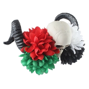 Close-up of gothic headband with black horns, skull, and colorful artificial dahlia flowers