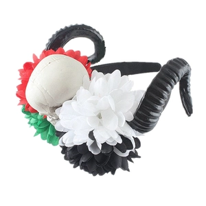 Detail of gothic Halloween headband with black ram horns, skull and vibrant silk flowers