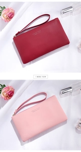 Detail of long wristlet wallets with pebbled leather texture in pink and burgundy