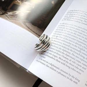 Artistic detail of 925 silver retro multi-layer spiral ring on vintage book pages