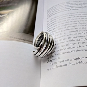 Artistic shot of a 925 silver multi-layer layered wrap ring on an open book page