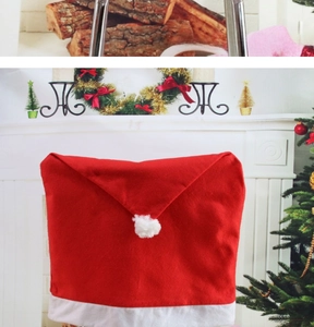 Detail of red and white Christmas hat chair cover with pom-pom in a festive home setting