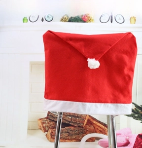 Detail of red and white Santa hat chair cover with plush pom-pom for Christmas decor