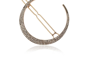 Dettaglio del fermaglio a luna dorato con pavé di strass trasparenti e base in metallo