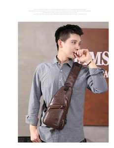 Detail of a brown leather chest bag showing texture, zippers, and adjustable shoulder strap