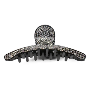 Macro shot of large black shark clip with colorful rhinestones on a white background