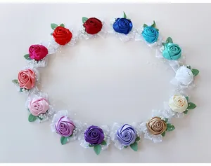 Detailed overhead view of assorted handmade satin rose corsages in thirteen vibrant colors