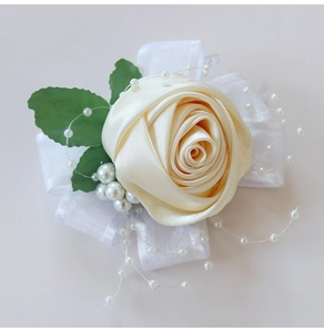 Detailed view of handmade cream satin rose corsage with white pearls and silk ribbons