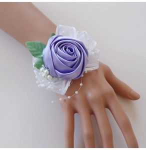 Detail of purple ribbon rose wrist corsage with lace trim and white pearl beads