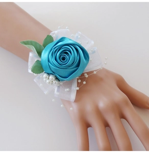 Detailed view of lake blue satin rose wrist corsage with white pearls and organza bow