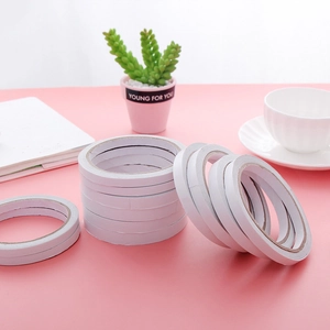 Strong white double-sided adhesive tape rolls for office supplies on pink background