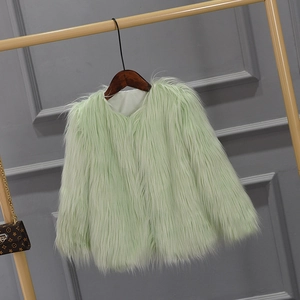 Detail of light green faux fur coat texture showing soft plush fabric on a wooden hanger