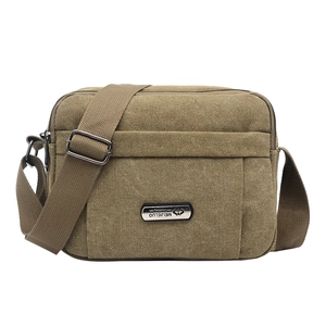 Detail of khaki canvas chest bag showing durable fabric and silver metal brand logo