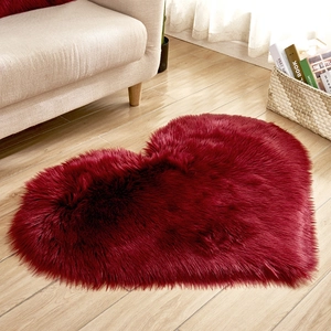 Wine red heart-shaped plush rug on a light wood floor in a cozy living room scene