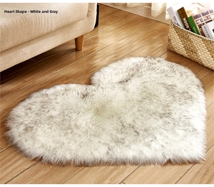 Close-up of heart-shaped plush rug in white and grey faux fur on wooden floor