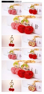 Detailed close-up showing pink crystal rhinestone cherry keychain with golden leaf and hook