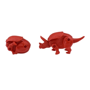 Macro detail of red triceratops dinosaur transformation toy from egg to standing form