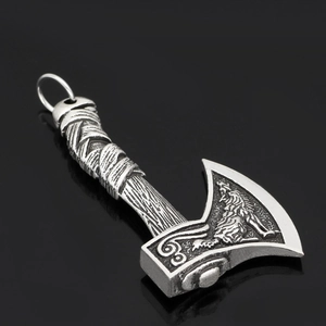 Close-up of Viking axe pendant with intricate Celtic wolf and raven carvings