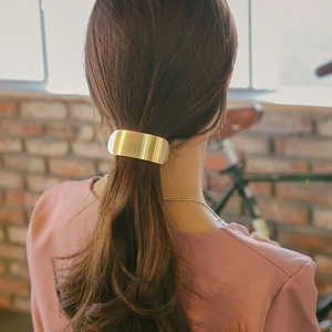 Barrette à cheveux minimaliste en métal doré sur une queue de cheval basse pour femme
