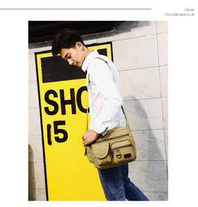 Detail view of khaki canvas messenger bag featuring multiple front flap pockets and zippers