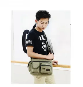 Army green canvas crossbody bag with multiple functional utility pockets on model