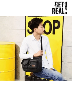Close-up of black canvas crossbody chest bag for men showing multi-pocket design on model