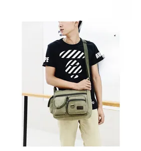 Detail of military green canvas crossbody bag with multi-pocket design on model