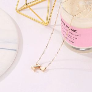 Detail of a golden Z-letter and heart pendant necklace with a delicate chain
